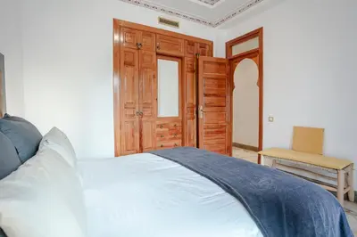 a bedroom with a white bed and a chair at Marrakech Palmeraie 2, 2-bedroom appartment, G1 , swimming pool residence, in Marrakech