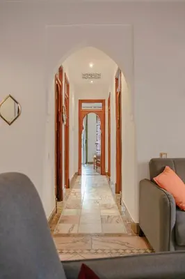 a hallway with two couches and an archway at Marrakech Palmeraie 2, 2-bedroom appartment, G1 , swimming pool residence, in Marrakech