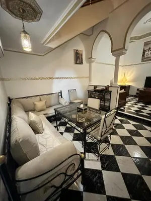a living room with a couch and a glass table at Riyad Ambre in Marrakech