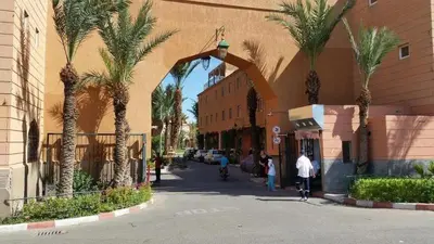 a group of people riding bikes down a street with palm trees at Riyad Ambre in Marrakech