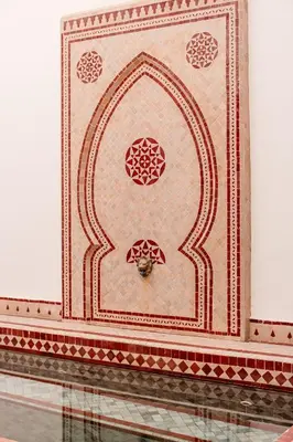 a tiled wall with a fountain in a building at Authentic Guesthouse Peral in the heart of Medina in Marrakech