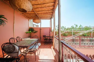 a patio with a table and chairs on a balcony at Authentic Guesthouse Peral in the heart of Medina in Marrakech