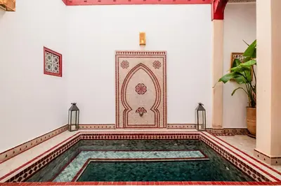 a pool in a room with a tile floor and a mosque at Authentic Guesthouse Peral in the heart of Medina in Marrakech