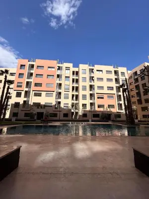 a large building with a courtyard in front of it at Appartement Moderne - Accès Piscines et Fitness in Marrakech