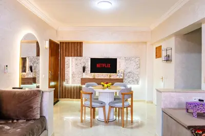 a living room with a table and chairs and a couch at Stylish Apartment in Gueliz by Train And Majorelle in Marrakech