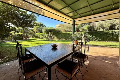a patio with a table and chairs under a canopy at Apartment with big private garden in Palmeraie in Marrakech