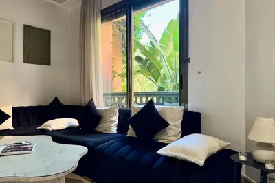a blue couch in a living room with a window at Apartment with big private garden in Palmeraie in Marrakech