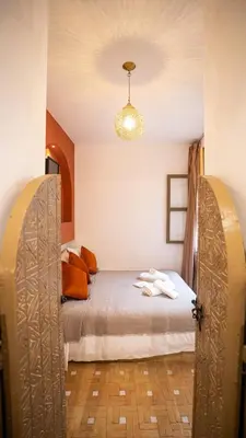 a bedroom with a bed with an open door at Riad Alaya by Maison Amellal in Marrakech
