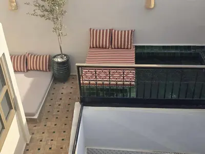 a balcony with two pillows and a plant at Riad Alaya by Maison Amellal in Marrakech