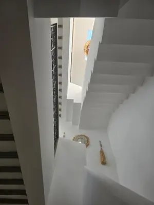 a white staircase in a house with a mirror at Riad Alaya by Maison Amellal in Marrakech