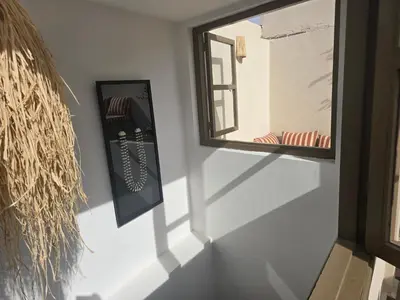 a mirror on a wall next to a window at Riad Alaya by Maison Amellal in Marrakech