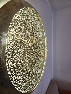 a gold and white plate on a wall at Riad Alaya by Maison Amellal in Marrakech