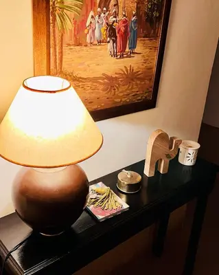 a lamp sitting on a table next to a painting at Riad privé 3 chambres, pdj inclus, 10 min Jema El Fna in Marrakech
