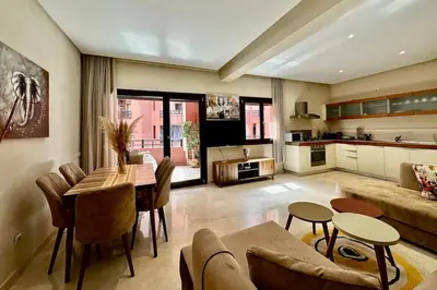 a large living room with a table and a kitchen at 2 bedroom apartment in Plaza central Gueliz in Marrakech