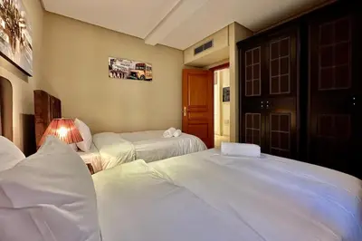 a hotel room with two beds and a lamp at 2 bedroom apartment in Plaza central Gueliz in Marrakech