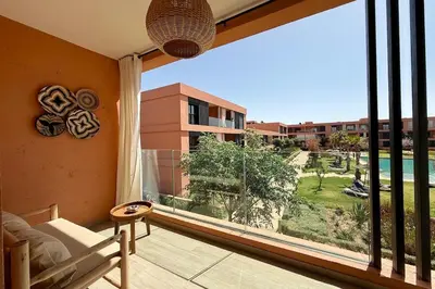 a bedroom with a large window with a view of a building at Domaine de Noria with terrace and Pools in Marrakech