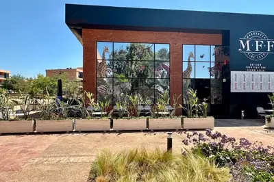 a building with a lot of plants in front of it at Domaine de Noria with terrace and Pools in Marrakech