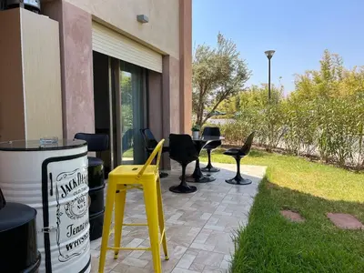 a patio with a table and chairs next to a building at Prestigia Agate 5 minute from Airport in Marrakech