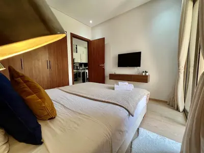 a bedroom with a large bed and a television at Prestigia Agate 5 minute from Airport in Marrakech