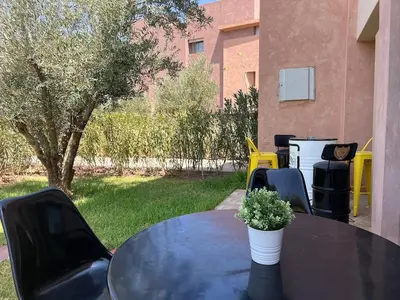 a black table with a potted plant on top of it at Prestigia Agate 5 minute from Airport in Marrakech