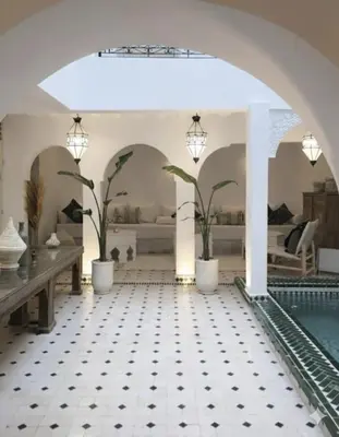 a living room with a pool and a tile floor at Riad de charme privatisé au cœur de la médina in Marrakech