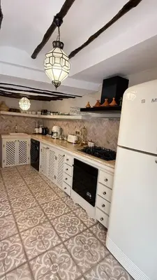 a kitchen with a white refrigerator and a stove at Riad de charme privatisé au cœur de la médina in Marrakech