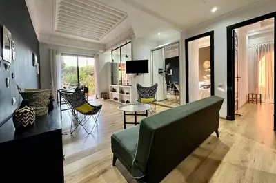 a living room with a green couch and chairs at Garden Aparment in Palmeraie 2 in Marrakech