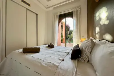a bedroom with a large white bed with a window at Garden Aparment in Palmeraie 2 in Marrakech