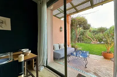an open door to a patio with a couch outside at Garden Aparment in Palmeraie 2 in Marrakech