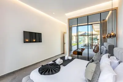 a bedroom with a white bed and a tv on a wall at Prestige Twin Villa with Splendid View in Marrakech