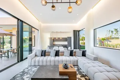 a living room with a white couch and large windows at Prestige Twin Villa with Splendid View in Marrakech