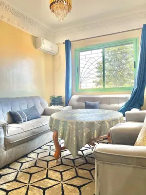 a living room with a couch and a table at Modern Apt 10min Airport Balcony & Wi-Fi in Marrakech
