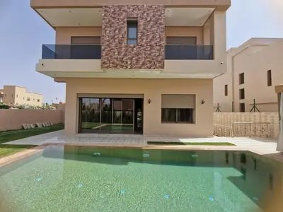 a house with a swimming pool in front of a house at Luxury villa with heated pool and private Hammam in Marrakech