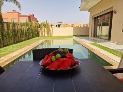 a bowl of fruit on a table in front of a pool at Luxury villa with heated pool and private Hammam in Marrakech