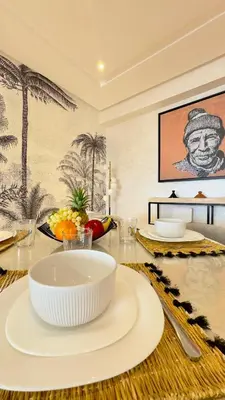 a dining room with a table with white plates on it at New Appart cosy et raffiné avec piscine et Jacuzzi à Guéliz in Marrakech