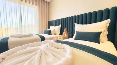 a bedroom with two beds and a large window at New Appart cosy et raffiné avec piscine et Jacuzzi à Guéliz in Marrakech