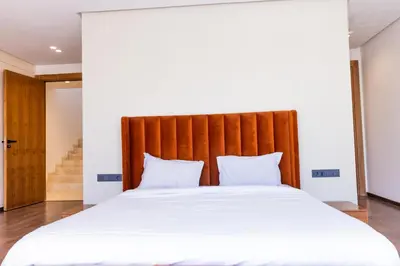 a large bed with white sheets and a wooden headboard at Villa terracotta in Marrakech