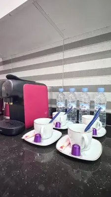 a table topped with cups and saucers with water bottles at Duplex Élégance et Confort avec piscine au Cœur de Marrakech in Marrakech
