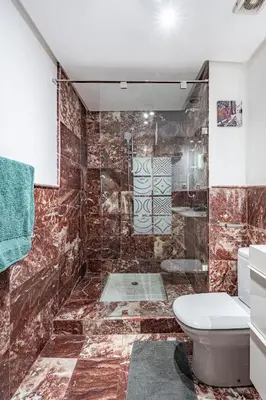 a bathroom with a toilet and a glass shower at Majorelle Place in Marrakech
