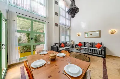a dining room with a table and a couch at Majorelle Place in Marrakech