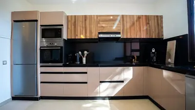 a kitchen with stainless steel appliances and wooden cabinets at Appart calme & central, piscine, proche médina et place Jemaa El Fna in Marrakech