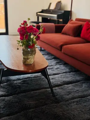 a vase with flowers on a table in a living room at Designer apartment with south-facing terrace in Marrakech