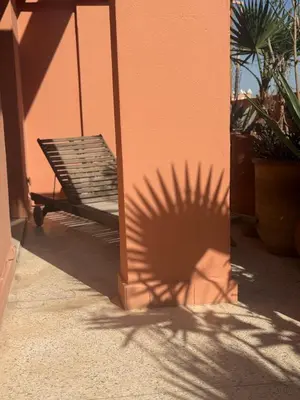 a shadow of a building with a bench on the side at Designer apartment with south-facing terrace in Marrakech