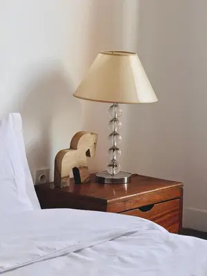 a lamp on a night stand next to a bed at Designer apartment with south-facing terrace in Marrakech