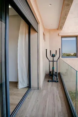 a room with a gym with a window and a treadmill at Villa Nerolia - Marrakech in Marrakech
