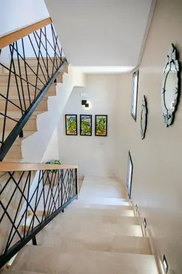 a staircase in a home with white walls and wooden stairs at Villa Nerolia - Marrakech in Marrakech