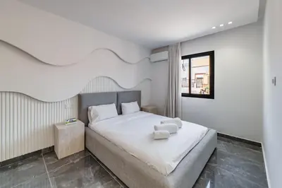 a bedroom with a bed with white sheets and a window at Appartement au cœur de Guéliz in Marrakech