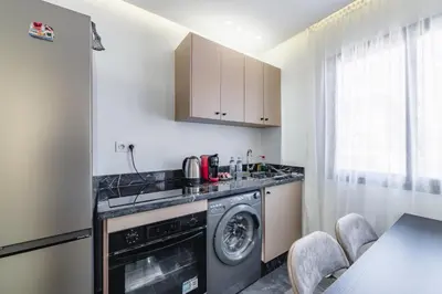 a kitchen with a washer and dryer next to a table at Appartement au cœur de Guéliz in Marrakech