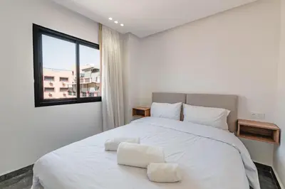 a bedroom with a white bed with a window at Appartement au cœur de Guéliz in Marrakech