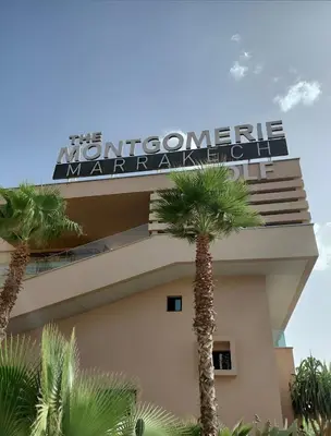 a sign on the side of a building with palm trees at prestigia urbane appartement marrakech in Marrakech